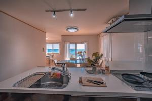 a kitchen with a sink and a counter top at 波音ハウス湯河原ー心地よい波Waveの音に包まれる癒しの別荘BBQ可 in Yugawara