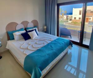 een slaapkamer met een groot bed met een blauwe deken bij Wateera Jebel Sifah-Beachfront in As Sīfah +35 foto's