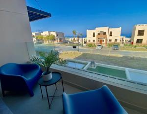 een kamer met twee stoelen en een raam met een potplant bij Wateera Jebel Sifah-Beachfront in As Sīfah