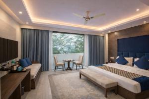 una camera da letto con un letto grande, un tavolo e delle sedie di Hotel Cardinal Express Oxmo Near IGI Airport Delhi With Free Aiport Drop a Nuova Delhi Altre 117 foto