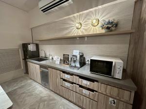 a kitchen with a counter with a microwave and a sink at HINOEN Hotel in Taipei