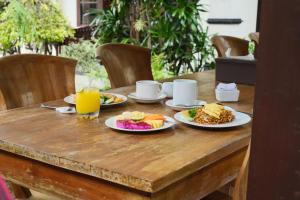 a wooden table with plates of breakfast food on it at Umah Gatra Ubud in Ubud +42 photos