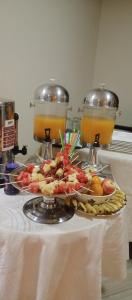 a tray of food on a table with two drinks at Trinity Resort Hotel & Spa in Kampala +21 photos