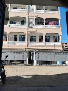 a building with balconies and a bike parked in front of it at Cutie Coastal Studio in Mombasa