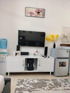 a living room with a large flat screen tv at Cutie Coastal Studio in Mombasa