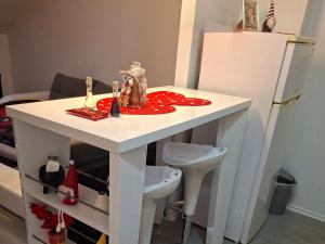 a small white table in a room with a refrigerator at Studio apartman Laura in Vinkovci +37 photos