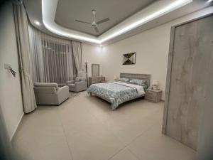 a bedroom with a bed and a couch and a chair at Rimal Chalet in Barka +16 photos