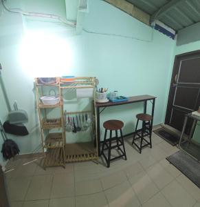 a small table and two stools in a room at 103 Lovely AC apartment with private kitchen in Bangkok