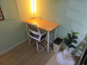 a desk with a chair and a plant in a room at 103 Lovely AC apartment with private kitchen in Bangkok +12 photos
