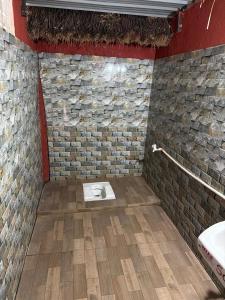a bathroom with a toilet in a brick wall at SS Aadhya Retreat in Payikāpuram