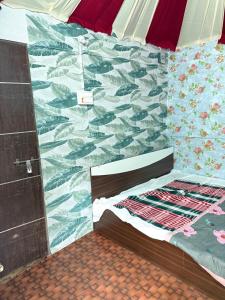a bedroom with a bed and a wall with a mural at SS Aadhya Retreat in Payikāpuram +7 photos