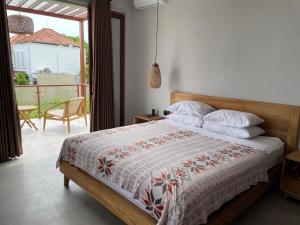 a bedroom with a bed and a balcony at Rumah Melissa - Modern Boho 3BR Brand New Villa in Sanur in Sanur +56 photos