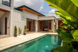 a swimming pool in front of a house at Rumah Melissa - Modern Boho 3BR Brand New Villa in Sanur in Sanur