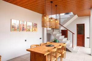 a dining room with a wooden table and stairs at Rumah Melissa - Modern Boho 3BR Brand New Villa in Sanur in Sanur