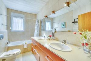 a bathroom with two sinks and a toilet and a tub at Ideal Property Mallorca - Villa Feel Good in Alcudia +23 photos