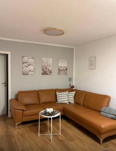 un soggiorno con un divano marrone e un tavolo di Haus Merle a Tossenserdeich