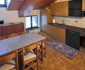 a kitchen with a counter and a table with chairs at Casa Ilaria Lavarone in Lavarone