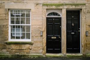 two black doors on a stone building with windows at Sun Street Retreats in Lancaster