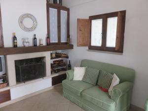 - un salon avec un canapé vert et une cheminée dans l'établissement Trullo Vacanza, à Alberobello