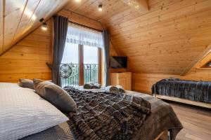 a bedroom with a large bed and a window at Drewniane Zacisze in Biały Dunajec