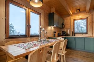 a kitchen and dining room with a wooden table and chairs at Drewniane Zacisze in Biały Dunajec +21 photos