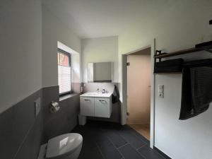 a bathroom with a white toilet and a sink at Gemütliche Ferienwohnung in Hüttblek in Hüttblek