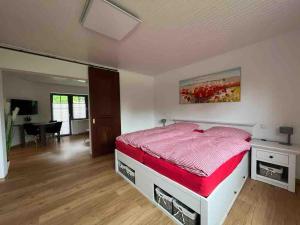a bedroom with a large bed with a red comforter at Gemütliche Ferienwohnung in Hüttblek in Hüttblek