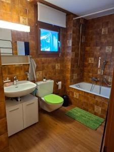 a bathroom with a toilet and a sink and a tub at Lärchenwald Lodge in Bellwald