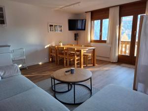 a living room with a table and a dining room at Lärchenwald Lodge in Bellwald