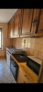 a kitchen with wooden cabinets and a stove top oven at le flocon chaud in La Bresse