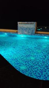een zwembad 's nachts met blauw water bij Hotel Urban chant in Rishīkesh