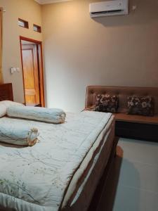 a bedroom with two beds and a couch in it at D 'Jambon Escape in Yogyakarta