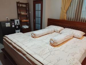 a bed with pillows on it in a bedroom at D 'Jambon Escape in Yogyakarta