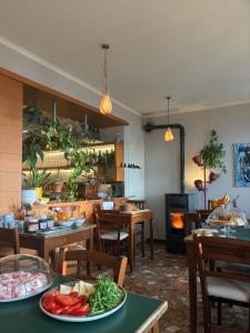 a restaurant with tables and chairs with vegetables on them at diana rooms in Lusiana