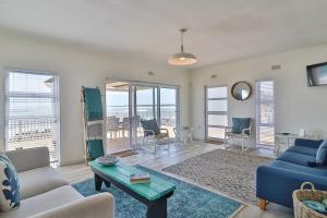a living room with a blue couch and a table at On the Rocks in Yzerfontein