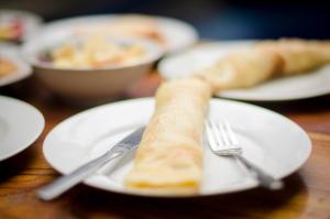 a piece of bread on a plate with a fork at Kabera House 1 in Ubud