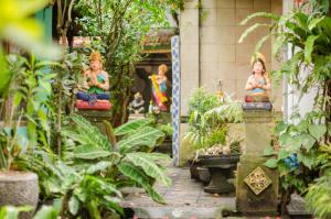 two statues of women sitting in a garden at Kabera House 1 in Ubud