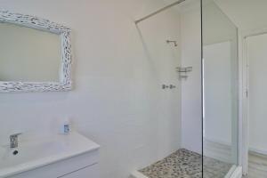 a white bathroom with a shower and a sink at On the Rocks in Yzerfontein +23 photos