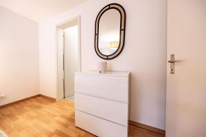 a white dresser in a room with a mirror at The R Apartment Hemmental in Schaffhausen