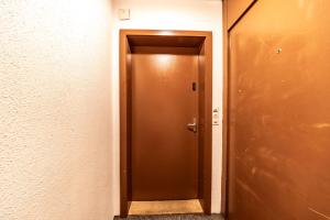 a brown door in a room with a wall at The R Apartment Hemmental in Schaffhausen