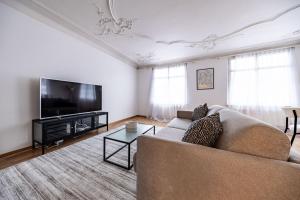 a living room with a couch and a flat screen tv at The R Apartment Hemmental in Schaffhausen