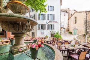 una fontana in un cortile con tavoli e sedie di Chambre indépendante maison Typique Provençale a Seillans Altre 3 foto
