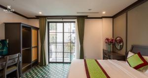 una camera d'albergo con un letto e un balcone di Nature Hotel - Ba Dinh a Hanoi Altre 101 foto