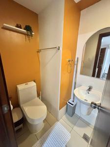 a bathroom with a toilet and a sink at NM 1BR Condo with Balcony at Horizons 101 in Cebu City +1 photo