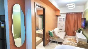 a room with a mirror and a living room at NM 1BR Condo with Balcony at Horizons 101 in Cebu City