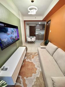 a living room with a couch and a flat screen tv at NM 1BR Condo with Balcony at Horizons 101 in Cebu City