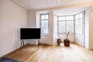 a living room with a flat screen tv in a room with windows at The R Apartment Randen in Schaffhausen +33 photos
