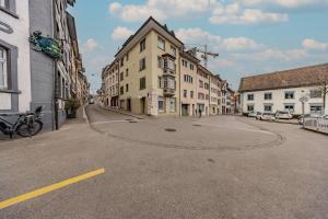 an empty street in a city with buildings at The R Apartment Randen in Schaffhausen