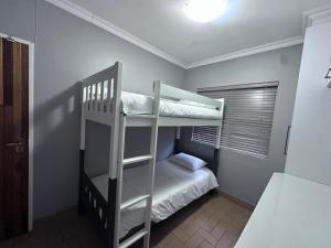 a bedroom with two bunk beds and a bed at Forest and Ferns in Graskop