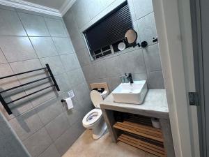 a bathroom with a sink and a toilet at Forest and Ferns in Graskop +13 photos